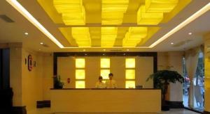 泉州Super 8 Hotel Quanzhou Xinchezhan Branch的两个人站在大厅的柜台上