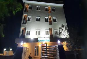 un edificio blanco alto con un cartel delante en POP 84142J Krishnapatnam Grand Inn, en Muttukūru