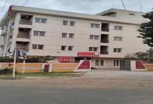 un gran edificio de apartamentos frente a una calle en POP 84142J Krishnapatnam Grand Inn, en Muttukūru