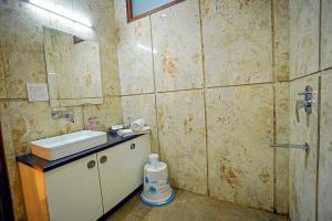 a bathroom with a sink and a mirror at Hotel O Rajiv Gandhi Bus Stop Bangalore Formerly Maharaja in Jālahalli