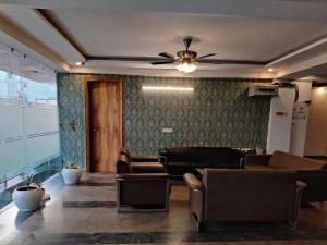 a waiting room with chairs and a ceiling fan at Hotel O Rajiv Gandhi Bus Stop Bangalore Formerly Maharaja in Jālahalli