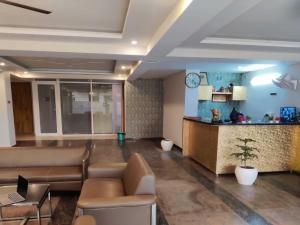 a lobby of a hospital with a couch and a counter at Hotel O Rajiv Gandhi Bus Stop Bangalore Formerly Maharaja in Jālahalli +10 photos