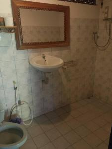 ein Badezimmer mit Waschbecken und Toilette in der Unterkunft ออร์คิดไฮบิสคัส เกสท์เฮ้าส์ in Sukhothai