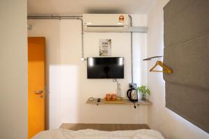 a room with a bed and a tv on a wall at Kenny Hill Boutique Hotel near Borneo Medical Centre Kuching in Kuching