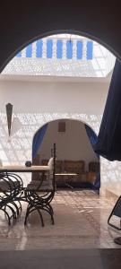 a room with benches and a table and a window at Riad Diaz Taghazout in Taghazout