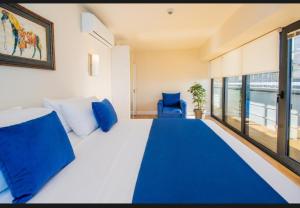 ORBI CITY - Luxury Prestige Hotel في باتومي: غرفة نوم بسرير كبير مع وسائد زرقاء