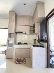 a kitchen with white cabinets and a sink at Moses Homestay, Yogyakarta in Beran-kidul