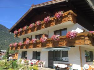 ein Gebäude mit Blumenkästen auf einem Balkon in der Unterkunft Haus Moosbrugger in Bach