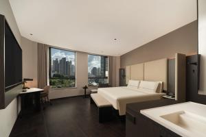 ein Hotelzimmer mit einem Bett und einem Waschbecken in der Unterkunft Atour Hotel Shanghai The Bund Yuyuan Subway Station in Shanghai + 50 Fotos