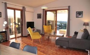 a living room with a couch and yellow chairs at Serene Serenity in Paphos
