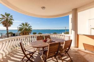 a table on a balcony with a view of the ocean at Utković Beachfront Apartments in Vrsi