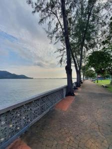 un marciapiede con alberi accanto a uno specchio d'acqua di Comfy and Cosy Place for Muslims a Lumut