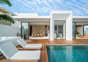 a villa with a swimming pool and a house at Cape Azure Resort Samui by Thalsea in Plai Laem