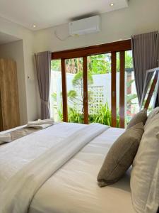 Un dormitorio con una cama con almohadas y una ventana. en Villa with private pool, en Panji
