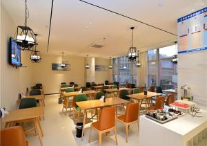 un ristorante con tavoli e sedie in una caffetteria di City Comfort Inn Kunming Nanping Pedestrian Street Wangfujing a Kunming