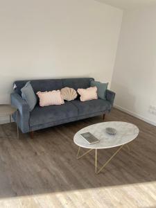 a living room with a blue couch and a table at Maison Mado in La Chaize-Giraud