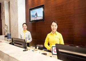 Due donne sedute alla scrivania in un ufficio di City Comfort Inn Nanning Jinhu Plaza Langxi Metro Station Exhibition a Nanning