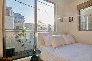 a bedroom with a bed and a large window at Mint House Ebisu - 3 Story, Artsy & Modern Home in Shibuya in Tokyo +115 photos