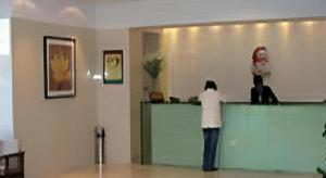 zwei Personen stehen an einer Theke in einem Zimmer in der Unterkunft Jinjiang Inn Select Yangzhou Shouxi Lake Siwangting Road in Yangzhou