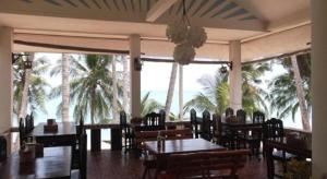 a restaurant with tables and chairs and palm trees at Palm Point Village in Mae Nam +148 photos
