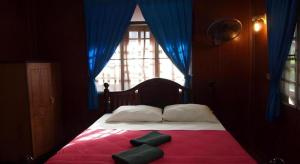 a bedroom with a bed with a red blanket and a window at Palm Point Village in Mae Nam