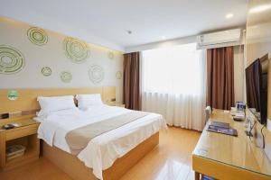 GreenTree Inn Huayin Huashan Town Huashan Scenicspot Express Hotel في Huayin: غرفة فندق مع سرير وتلفزيون