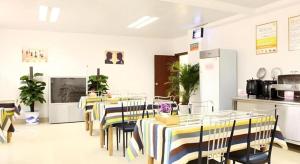 un ristorante con tavoli e sedie in una stanza di GreenTree Inn Nanjing Lishui District Lishui Airport Road Express Hotel a Lishui