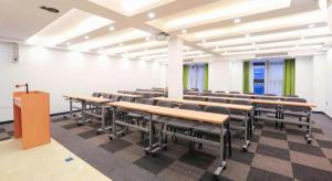 una classe con scrivanie e sedie in una stanza di 7Days Premium Chongqing Jiangbei International Airport Rongchuang a Chongqing