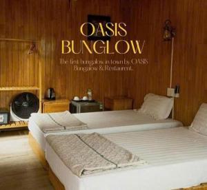two beds in a room with a sign that reads oasis bullpen at Catba Oasis Bungalows in Cat Ba +15 photos