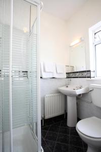 a white bathroom with a sink and a shower at Brooklodge Bed and Breakfast in Westport