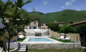 een zwembad in een tuin met stoelen en een huis bij Gustet 5 - Prosecco Hills Holidays in Miane