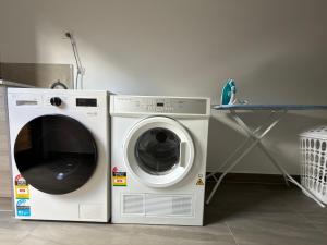 a washing machine and a dryer in a room at Stunning 4 X Bed Holiday Home In Kalkallo! in Kalkallo