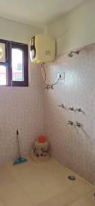 a bathroom with a blow dryer on the wall at East Home Stay in Dharmsala