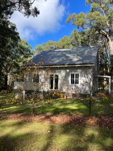 een oud stenen huis met een metalen dak bij The Red Hill Barn in Main Ridge