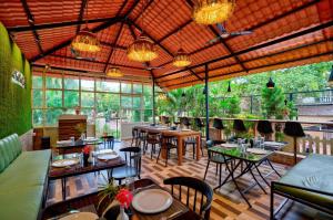a restaurant with tables and chairs and windows at Maya Beach Resort Near Vagator Petrol Pump Anjuna in Vagator