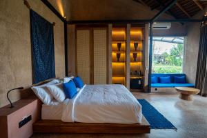 a bedroom with a bed with blue pillows at Terra Sayan in Ubud +50 photos