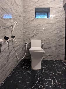 a bathroom with a toilet with a hose at Halfway Home Hilltop in Gokarna +17 photos