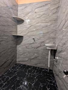 a bathroom with a sink and a stone wall at Halfway Home Hilltop in Gokarna