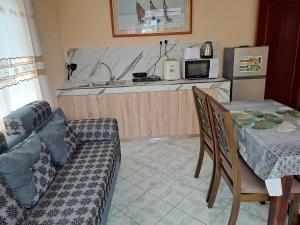 a living room with a couch and a table and a kitchen at Labour Villa in Mahébourg
