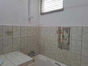 a bathroom with a bath tub and a window at Labour Villa in Mahébourg +24 photos