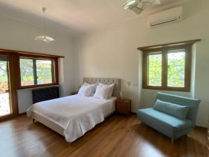 a bedroom with a bed and a blue chair at Villa Valentina in Bracciano +71 photos