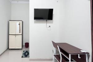 a dining room with a table and a refrigerator at RedDoorz Syariah Omah Audrey near RSI Kota Magelang in Kedungsari