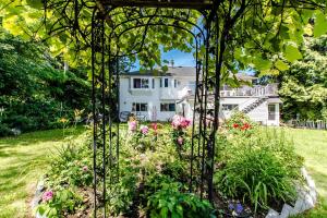 un jardín con flores y una casa de fondo en The Nesting Suite, en Surrey 12 fotos más