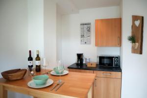 a small kitchen with a wooden table with wine bottles at Ferienwohnung Dicke Linde, 55qm in Schmallenberg