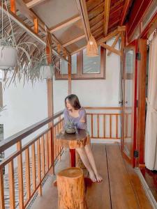 a woman sitting at a table in a room at Family Tan Thanh in Tân Thành (1)