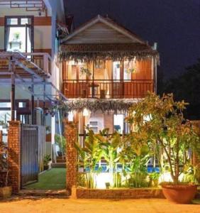 a house with a balcony with trees in front of it at Family Tan Thanh in Tân Thành (1)
