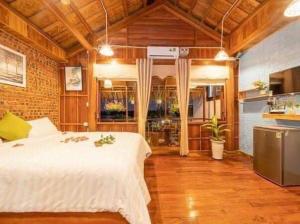 a bedroom with a large white bed and a kitchen at Family Tan Thanh in Tân Thành (1)