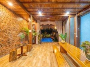 a living room with a bench and a brick wall at Family Tan Thanh in Tân Thành (1)