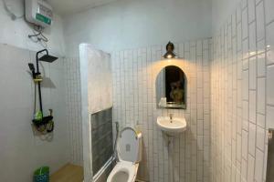 ジョグジャカルタにあるCapital O 94840 Unihomestay Malioboro Syariahのトイレと洗面台のあるバスルーム