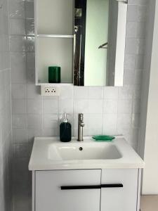 a bathroom with a white sink and a mirror at Sala Homestay in Ban Mae Nai
